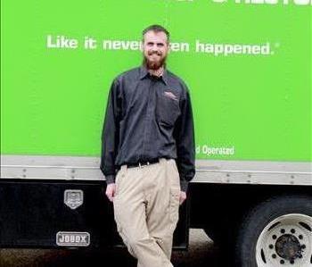 David standing in front of a green servpro box truck smiling